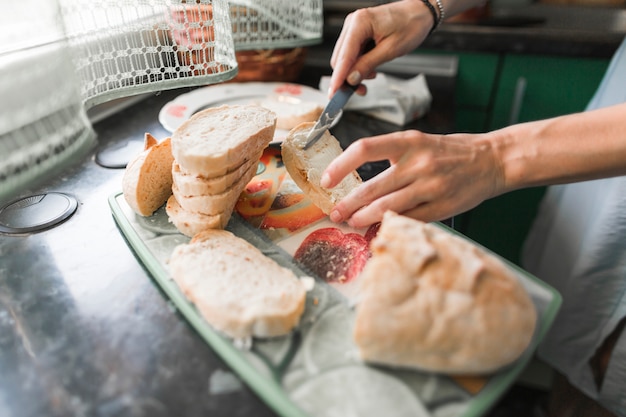 Zbliżenie osoby stosujące sera do kromki chleba