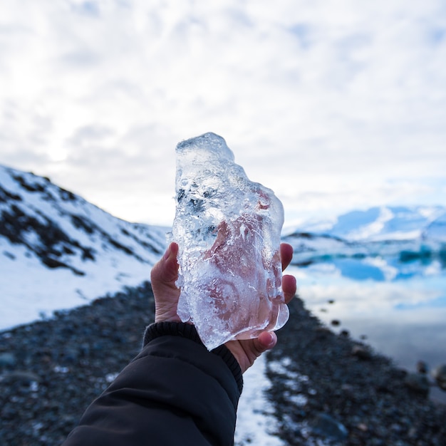 Zbliżenie osoby trzymającej lód w Islandii z rozmytym tłem