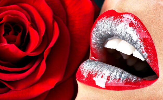 Zbliżenie piękne kobiece usta szminką błyszczący czerwony połysk i róża
