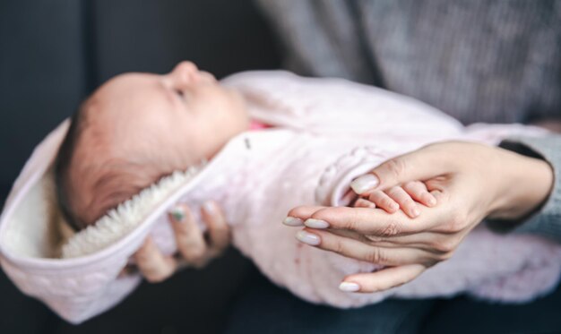 Zbliżenie pióra noworodka dziewczynki w ręku mamy