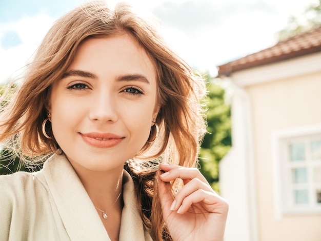 Zbliżenie portret pięknej blond modelki. Modna dziewczyna pozuje na ulicy