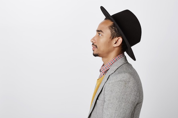 Bezpłatne zdjęcie zbliżenie profilu przystojny facet afroamerykanin hipster w garniturze i kapeluszu patrząc w lewo