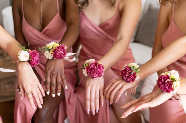 Zbliżenie przyjaciół noszących kwiaty na przyjęciu weselnym