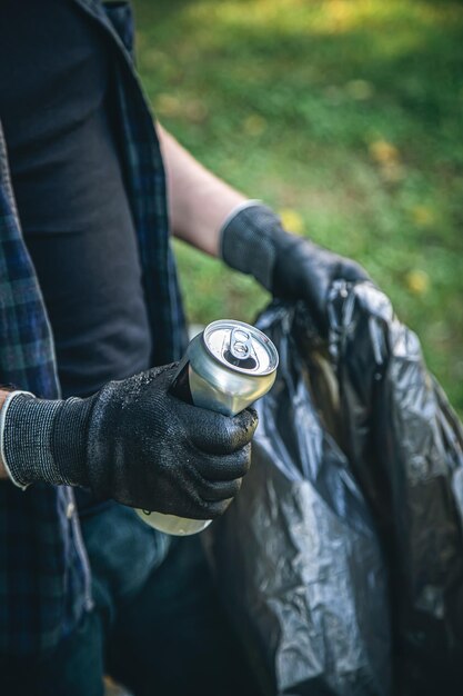 Zbliżenie puszka w rękach mężczyzny sprzątającego przyrodę ze śmieci