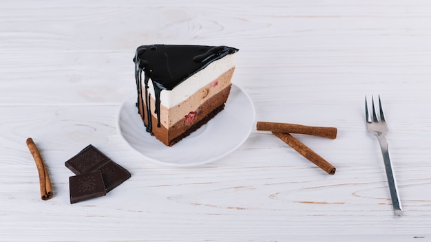 Bezpłatne zdjęcie zbliżenie: pyszne ciasto; cynamon; tabliczka czekolady; widelec