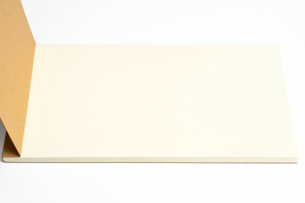 Zbliżenie rozpieczętowany dzienniczek z kartonowym hardcover i pustymi stronami odizolowywającymi na bielu.