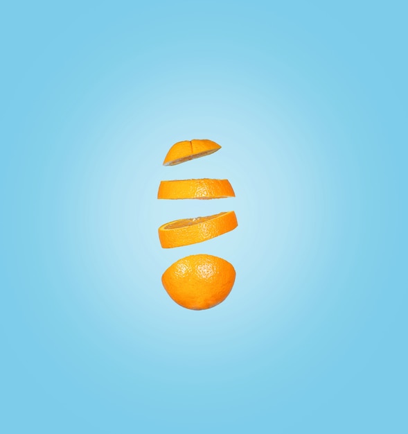 Bezpłatne zdjęcie zbliżenie spadające plasterki pomarańczy na białym tle na niebieskiej powierzchni