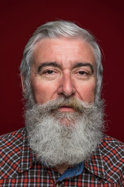 Zbliżenie starszy mężczyzna z szarego brodę na kolorowym tle