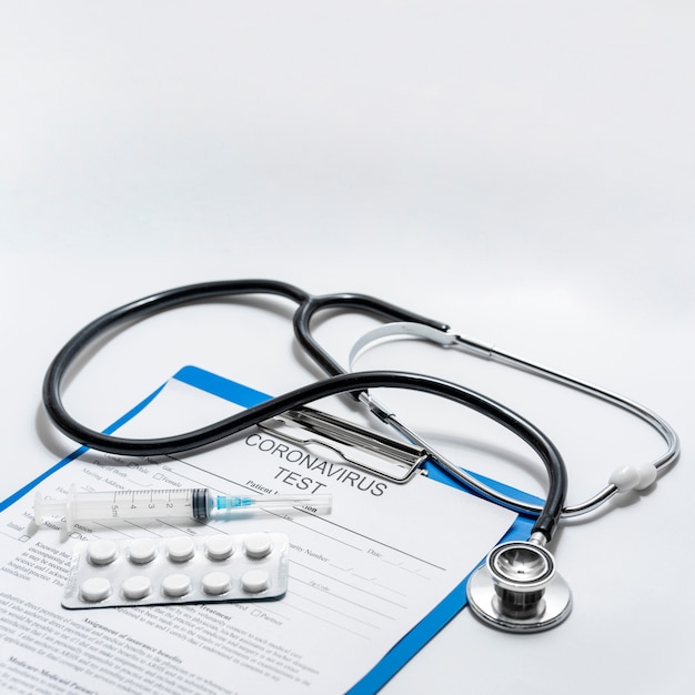Zbliżenie stetoskop z tabletkami i formularz medyczny