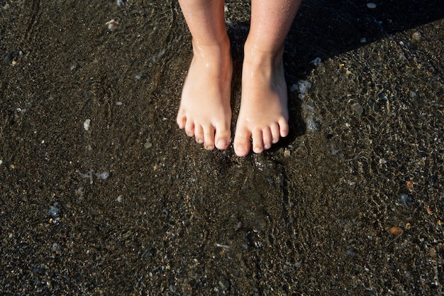 Bezpłatne zdjęcie zbliżenie stóp dzieci na plaży?