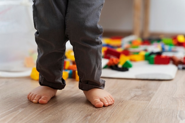 Zbliżenie stóp dziecka za pomocą rozmytych zabawek