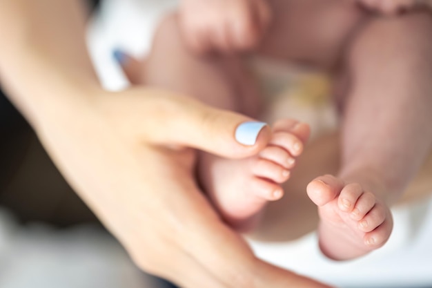 Bezpłatne zdjęcie zbliżenie stóp noworodka w rękach matki