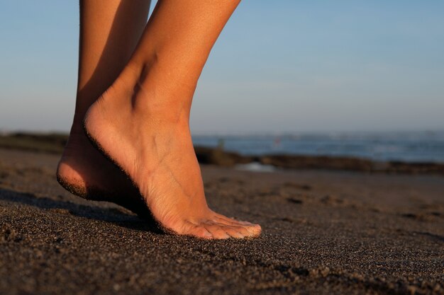 Zbliżenie. stopy na czarnym piasku. Bali