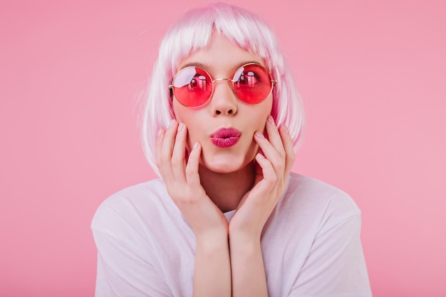 Bezpłatne zdjęcie zbliżenie strzał pięknej dobrej kobiety w różowych okularach przeciwsłonecznych wewnątrz zdjęcie europejskiej modnej dziewczyny nosi peruke