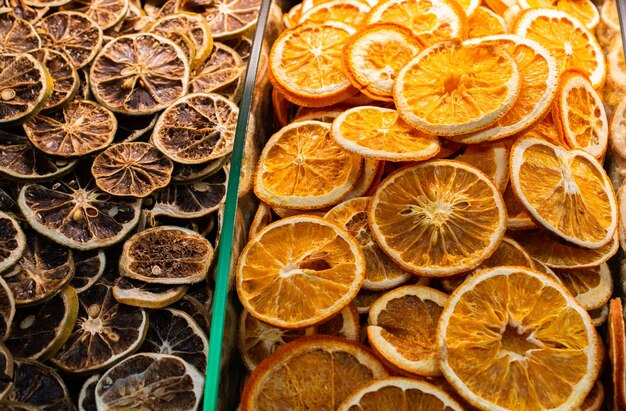 Zbliżenie suszonych pomarańczy i grejpfrutów w szklanych pojemnikach na rynku
