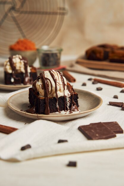 Zbliżenie świeżo upieczonego pysznego dyniowego czekoladowego brownie z lodami na talerzu