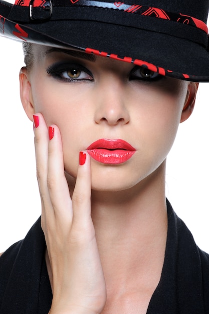 Bezpłatne zdjęcie zbliżenie twarzy pięknej kobiety z jaskrawoczerwonymi ustami i paznokciami w kapeluszu mody
