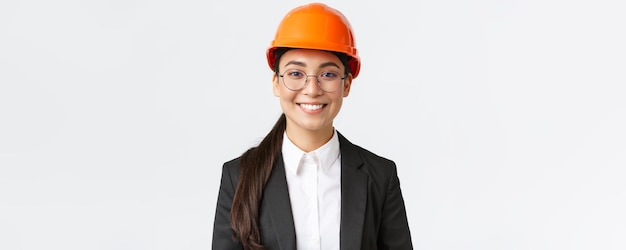 Zbliżenie Uśmiechnięta Profesjonalna Azjatycka Kobieta Inżynier Bizneswoman W Garniturze I Hełmie Ochronnym Mająca Inspekcję W Fabryce Wyglądającą Pewnie I Zadowoloną Stojącą Na Białym Tle