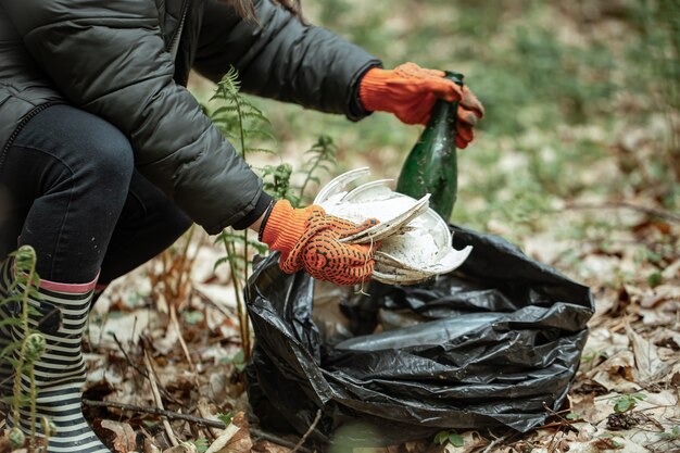 Zbliżenie wolontariusza oczyszcza naturę ze szkła, plastiku i innych zanieczyszczeń