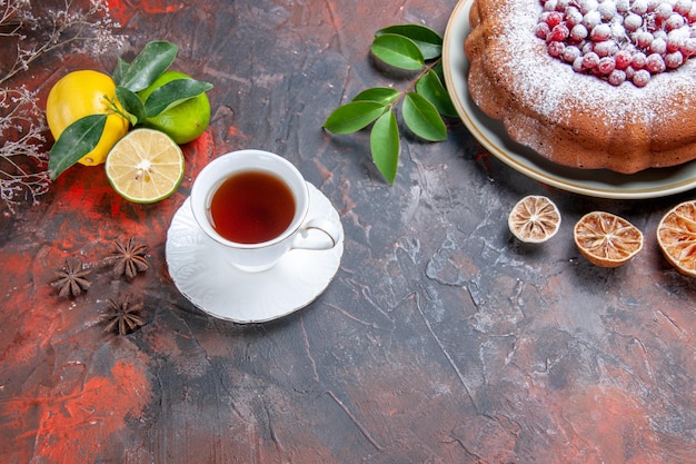 Zbliżenie z boku ciasto ciasto z czerwonymi porzeczkami owoce cytrusowe filiżanka herbaty anyż