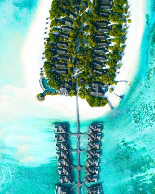 Zdjęcia lotnicze z domów zbudowanych nad morzem i na lądzie z drzewami na Malediwach