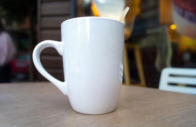 Zdjęcie białego ceramicznego kubka do kawy na zewnątrz