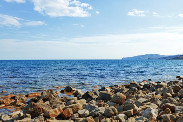 Zdjęcie kamienistego brzegu morza w tle
