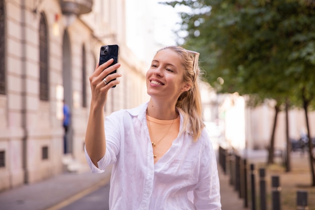 Zdjęcie ładnej kobiety robi selfie przy telefonie