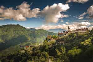 Bezpłatne zdjęcie zdjęcie lotnicze małej wioski na wzgórzu otoczonej zalesionymi górami