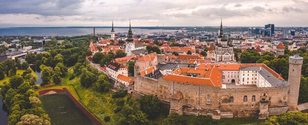 Zdjęcie lotnicze starego miasta w Tallinie z pomarańczowymi dachami, wieżami kościołów i wąskimi uliczkami