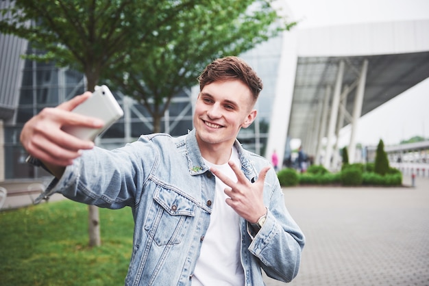 Bezpłatne zdjęcie zdjęcie młodego mężczyzny przed ekscytującą podróżą na lotnisku.