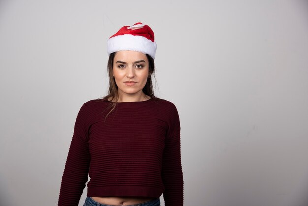 Zdjęcie młodej kobiety w Boże Narodzenie kapelusz patrząc w kamerę.