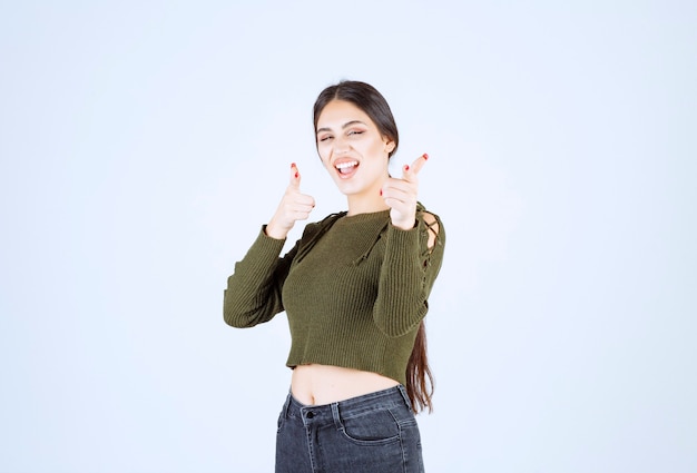 Zdjęcie modelu młodej kobiety stojącej i wskazując na bok palcem wskazującym
