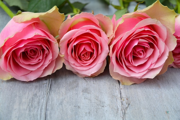 Zdjęcie zbliżenie różowych róż na powierzchni drewnianych