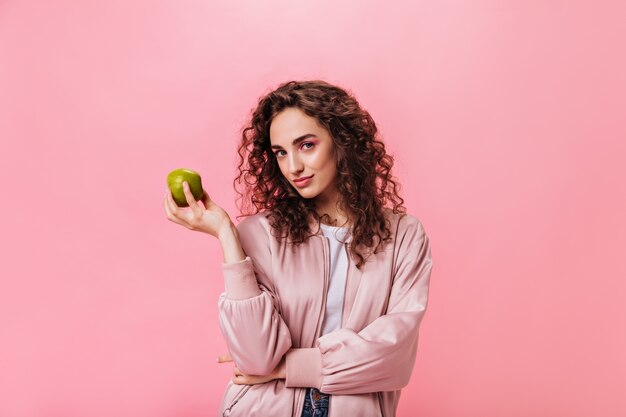 Zdrowa kobieta patrząc w kamerę i trzymając jabłko
