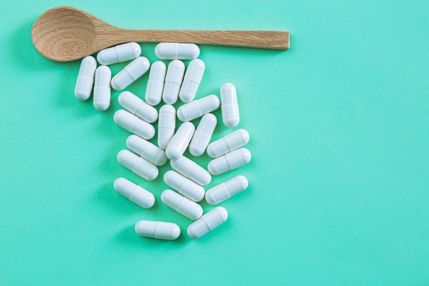 Zdrowa koncepcja z tabletkami i kapsułkami leków farmaceutycznych na jasnym jasnozielonym tle