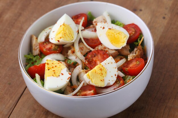 Zdrowa sałatka warzywna ze świeżych pomidorów, ogórków, cebuli, szpinaku, sałaty i sezamu na misce. menu dietetyczne