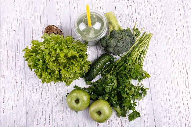 Zdrowe koktajl z zielonymi warzywami i owocami leżą na stole
