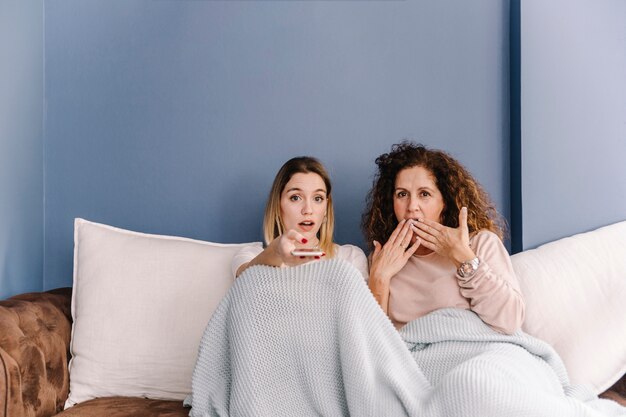 Zdziwione kobiety oglądające telewizję