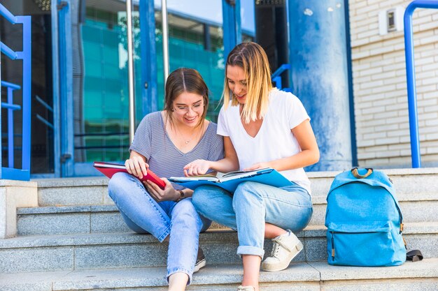 Żeńscy przyjaciele studiuje na uniwersyteckich krokach