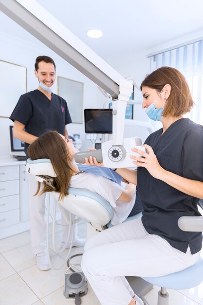 Żeński dentysta skanuje cierpliwych zęby z promieniowaniem rentgenowskim maszyną