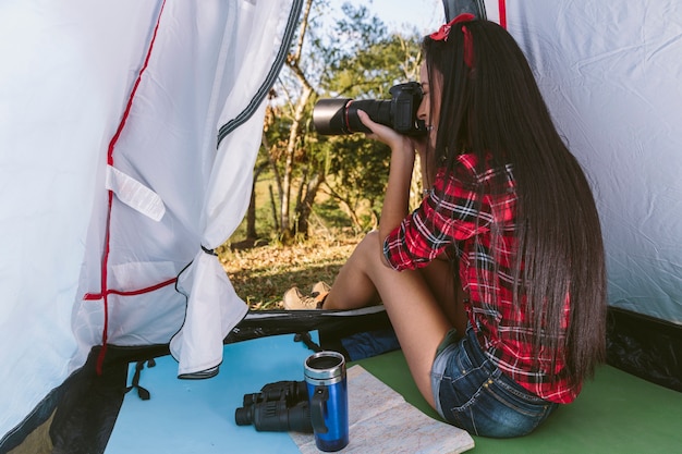 Bezpłatne zdjęcie Żeński fotograf bierze fotografię z kamerą w namiocie
