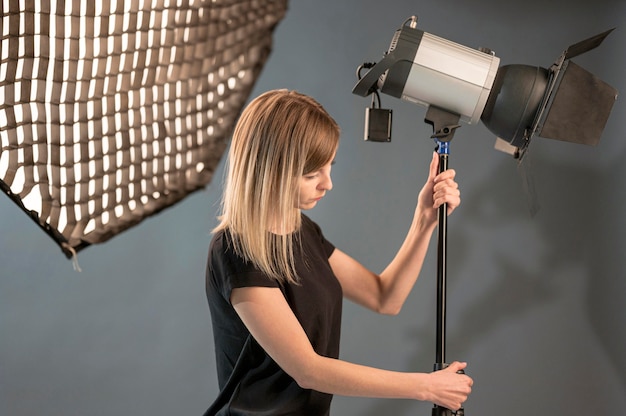 Żeński fotograf przystosowywa pracownianą lampę