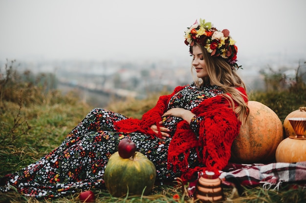 Bezpłatne zdjęcie Żeński portret. urocza kobieta w ciąży w długiej sukni i czerwieni s