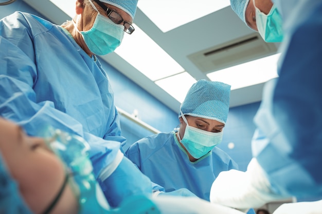 Bezpłatne zdjęcie zespół chirurgów wykonujących operację teatru operacyjnego