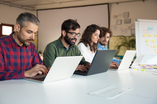 Zespół startowy współpracujący przy projekcie za pomocą laptopów