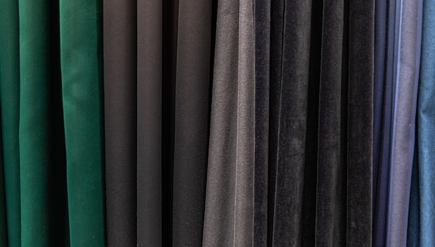 Zestaw ciemnych, wielobarwnych, gęstych tkanin o jednolitej fakturze, wybór materiałów w różnych kolorach.