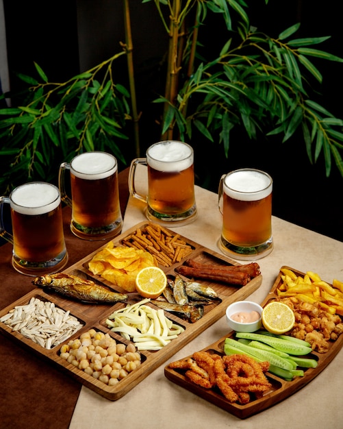 Bezpłatne zdjęcie zestaw do piwa z szklankami i półmiskami z przekąskami