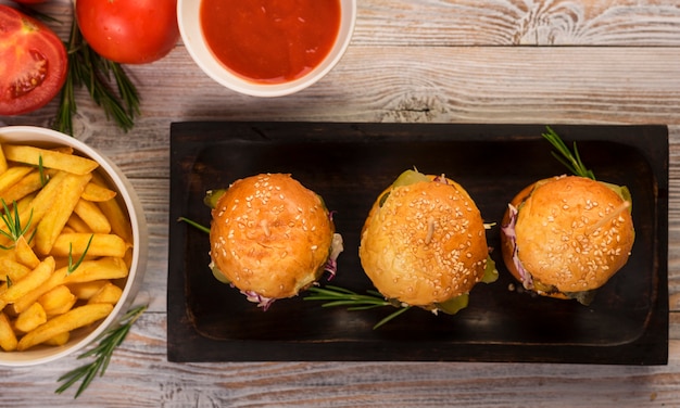 Bezpłatne zdjęcie zestaw klasycznych burgerów z frytkami i sosem na stole