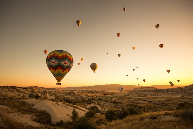 Zestaw kolorowych balonów latających nad ziemią w Kapadocji, Turcja